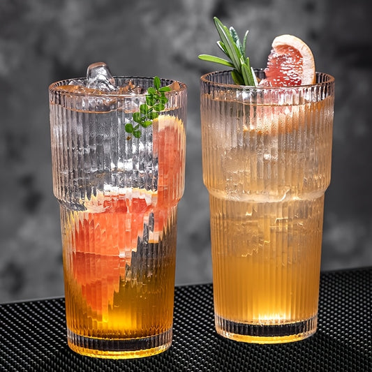 Detalhe de dois copos de vidro canelado texturado com bebidas frias e gelo sobre uma mesa minimalista da KURA Vibe
